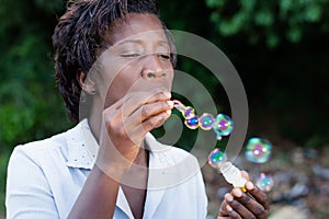 Pretty young woman blowing bubbles.