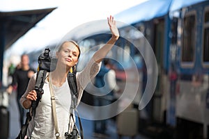 Pretty young woman boarding a train/having arrived to her destination photo