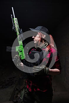 Pretty young woman in body armor with gun