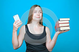 Pretty young woman with the books in the hands and mobile phone