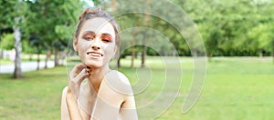 Pretty young woman with bright make up. Outdoor green portrait