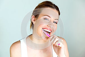 Pretty young woman brushing her teeth in the bathroom at home. photo