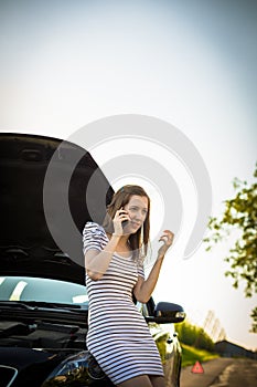 Pretty, young woman calling the roadside service