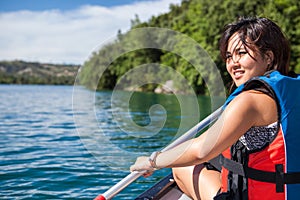 Pretty, young woman on a canoe on a lake