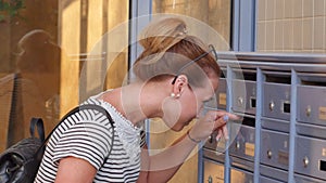 Pretty young woman checking her mailbox for new letters