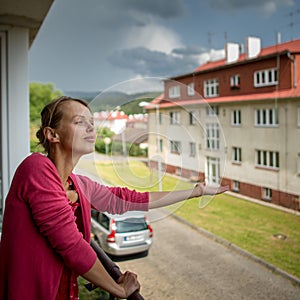 Pretty, young woman checking wether it is raining already