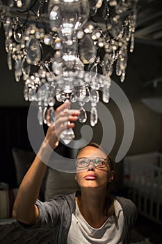 Pretty, young woman choosing the right chandelier