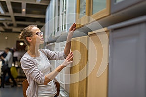 Pretty, young woman choosing the right furniture