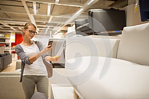 Pretty, young woman choosing the right furniture