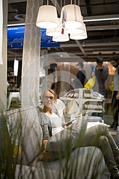 Pretty, young woman choosing the right furniture