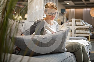 Pretty, young woman choosing the right furniture