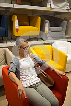 Pretty, young woman choosing the right furniture for her apartment