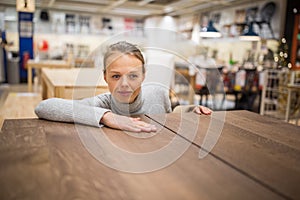 Pretty, young woman choosing the right furniture for her apartment in a modern home furnishings store