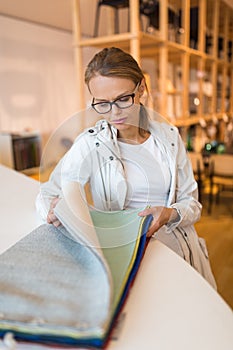 Pretty young woman  choosing the right material/color for her modern appartement interior