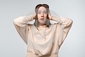 Pretty young woman covering ears with hands