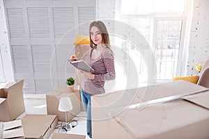 Pretty young woman creating list of her belongings