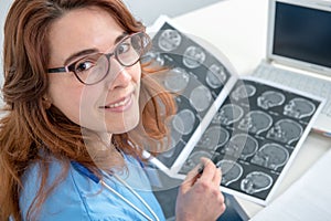 Young woman doctor looking at an x-ray in an office