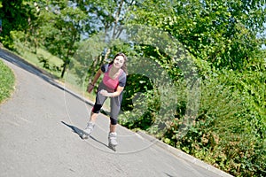 Pretty young woman doing rollerskate on a track