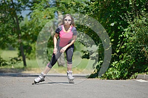 Pretty young woman doing rollerskate on a track