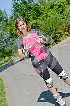 Pretty young woman doing rollerskate on a track