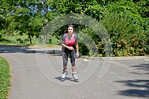 Pretty young woman doing rollerskate on a track