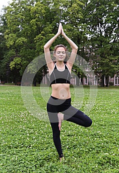 Pretty young woman doing yoga exercises.