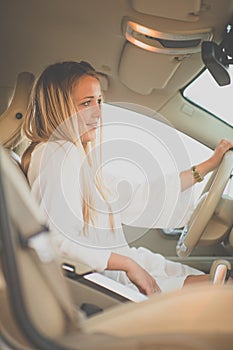 Pretty, young woman driving a car