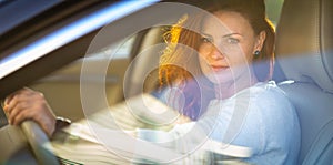 Pretty, young woman  driving a car