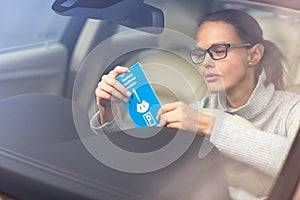 Pretty, young woman driving her elegant new car