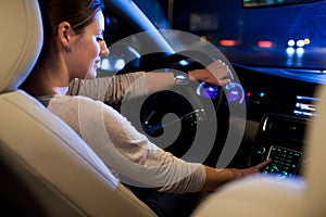 Pretty, young woman driving her modern car