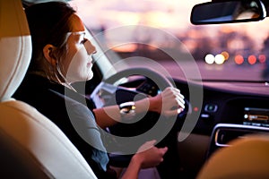 Pretty, young woman driving her modern car