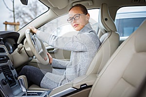 Pretty, young woman driving her new car