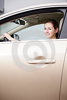 Pretty young woman driving her new car