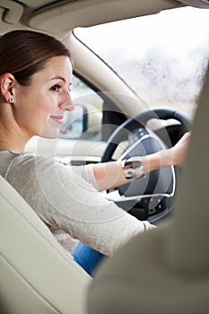 Pretty young woman driving her new car