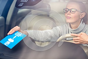 Pretty, young woman driving her new car