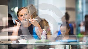 Pretty, young woman eating sushi in a restaurant