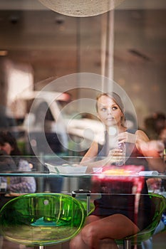 Pretty, young woman eating sushi in a restaurant