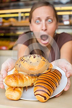 Pretty young woman eating sweets in the cafe. Bad habits. Health