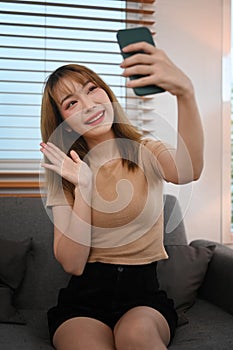 Pretty young woman enjoy chatting online or making video call on her smart phone