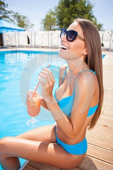 Pretty young woman is enjoying drink on vacation