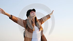 Pretty young woman enjoying time and sunset while standing on the rooftop.