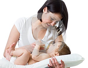 Pretty young woman feeding her baby from bottle