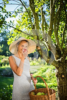 Pretty, young woman gardening in her garden