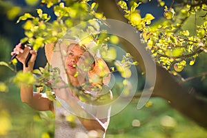 Pretty, young woman gardening in her garden