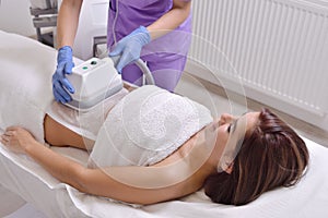 Pretty young woman getting cryolipolyse fat treatment in profess photo