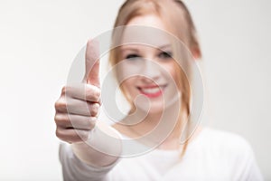 Pretty young woman giving a thumbs up sign