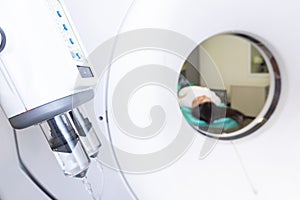 Pretty, young woman goiing through a Computerized Axial Tomography CAT Scan medical test examination in a modern