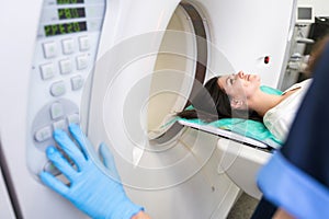 Pretty, young woman goiing through a Computerized Axial Tomography CAT Scan medical test examination in a modern