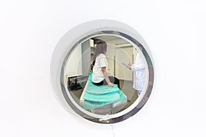 Pretty, young woman goiing through a Computerized Axial Tomography CAT Scan medical test examination in a modern