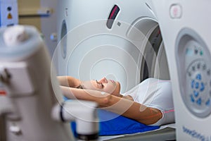 Pretty, young woman goiing through a Computerized Axial Tomography (CAT) Scan medical test/examination in a modern hospital